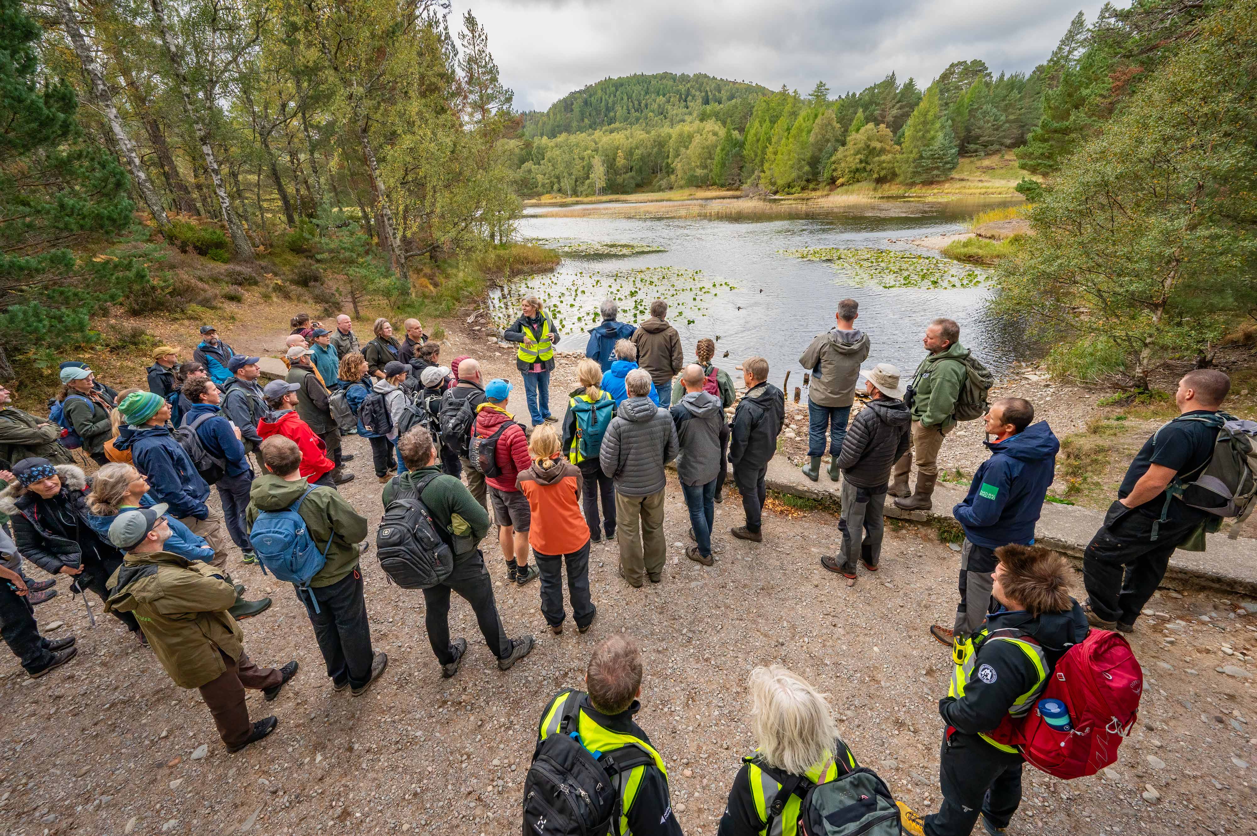 Delegates standing by a loch Delegates standing by a loch