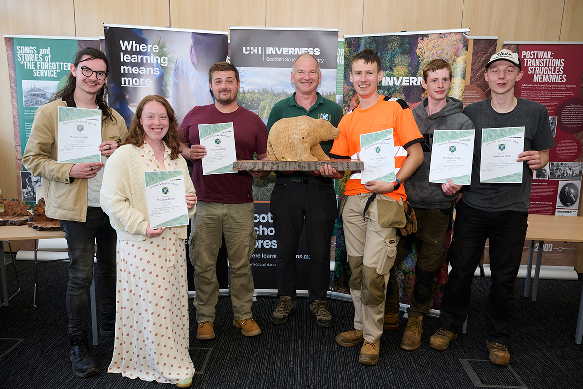 College students holding certificates at a prizegiving