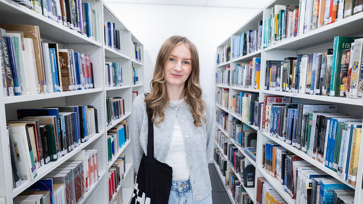 Female student Mhari Ross standing in library