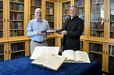 two people holding a chanter awards in a library setting