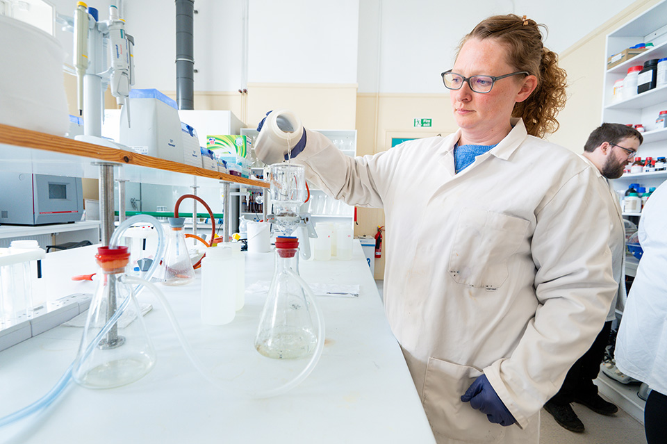 Researcher in a lab using equipment Researcher in a lab using equipment
