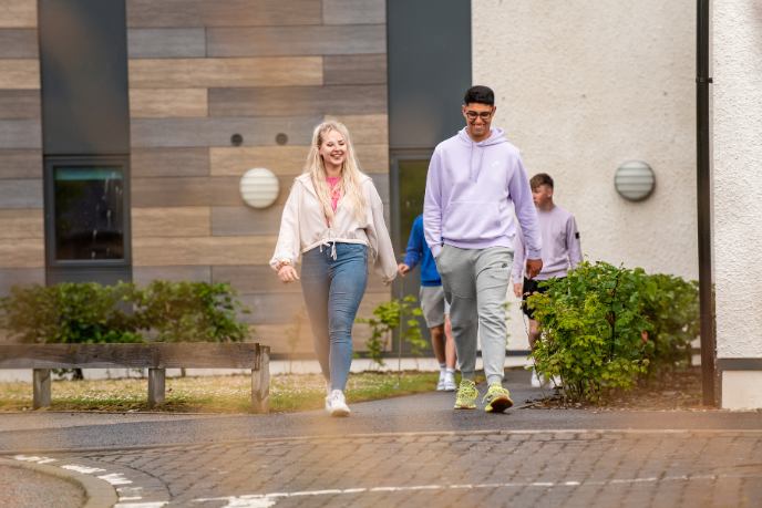 Two students walking outside student accommodation Two students walking outside student accommodation
